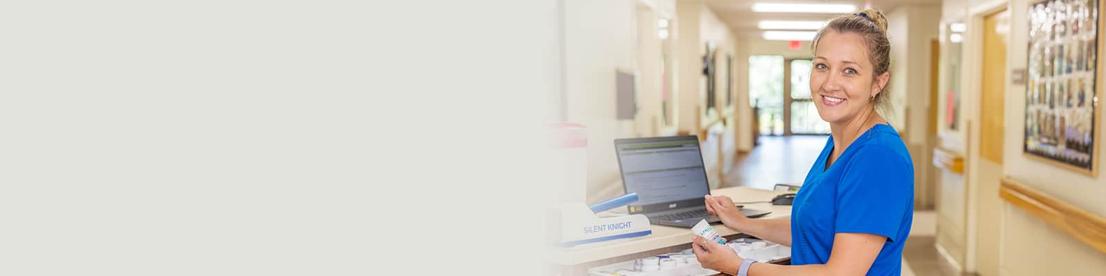 A nurse at a nurse's cart in the hallway at the Piedmont Post Acute facility